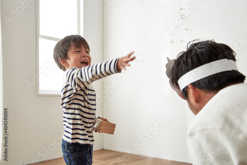 鬼役のお父さんに向かって豆まきをする男の子