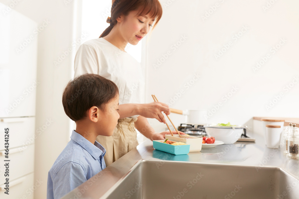 キッチンでお弁当を作る女性と寄り添う男の子 キッチンでお弁当を作る女性と寄り添う男の子