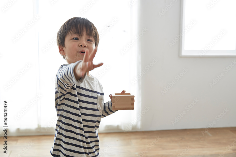 部屋の中で豆まきをする男の子