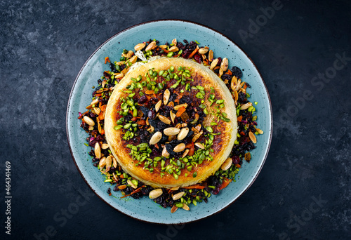 Traditional Persian tahdig jeweled javaher polow bride basmati rice with dried fruits and berries served as top view on a Nordic design plate with copy space photo