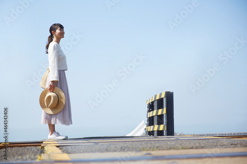 踏切で立ち止まって景色を見渡す女性 ,日本,大阪府,泉南市周辺 photo