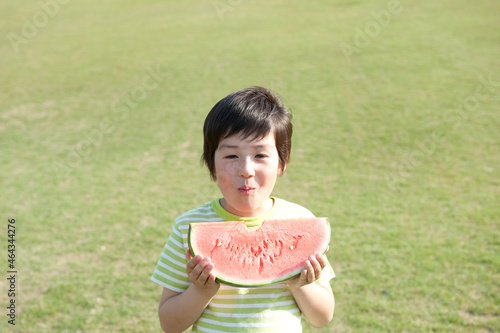 公園でスイカを食べる男の子 photo