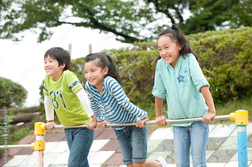 公園で鉄棒をする子供男女3人 公園で鉄棒をする子供男女3人