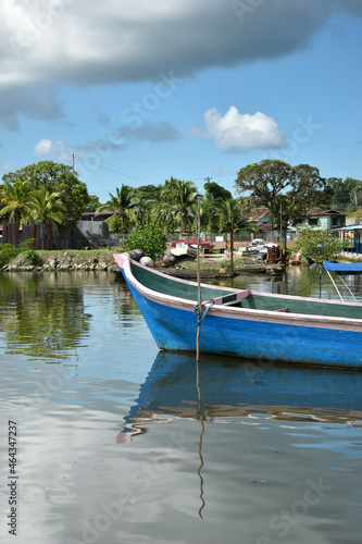 Boat in the port of Almirante on the Caribbean coast, beautiful reflection of the sky and clouds on the surface, Panama