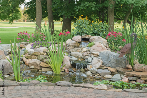 Mature landscaping around a backyard water feature created by the homeowner