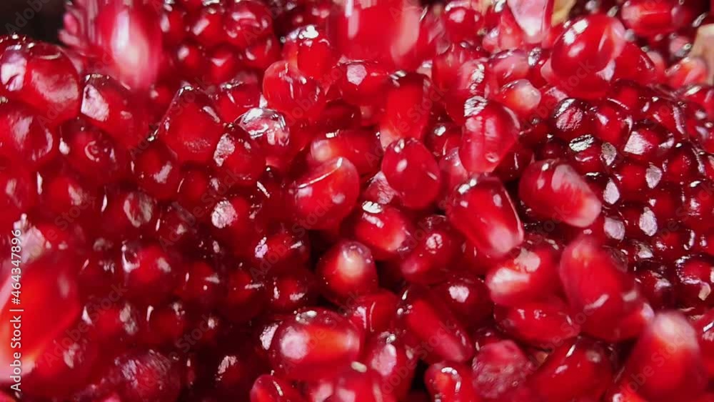 Close-up of delicious red pomegranate grains falling in slow motion Close-up of delicious red pomegranate grains falling in slow motion