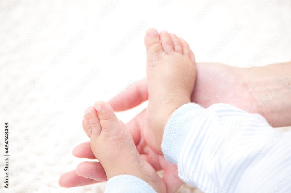 赤ちゃんの足を持つ母親の手 赤ちゃんの足を持つ母親の手