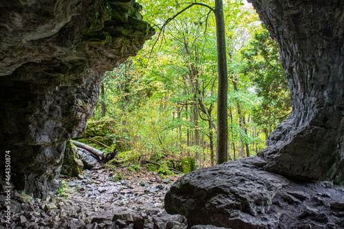 A view from inside of Bruce's Caves near Wiarton, Ontario, looking out towards the surrounding forest covered in Autumn-coloured leaves. photo