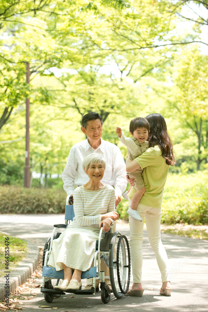 車椅子の老人夫婦と子供を抱く女性