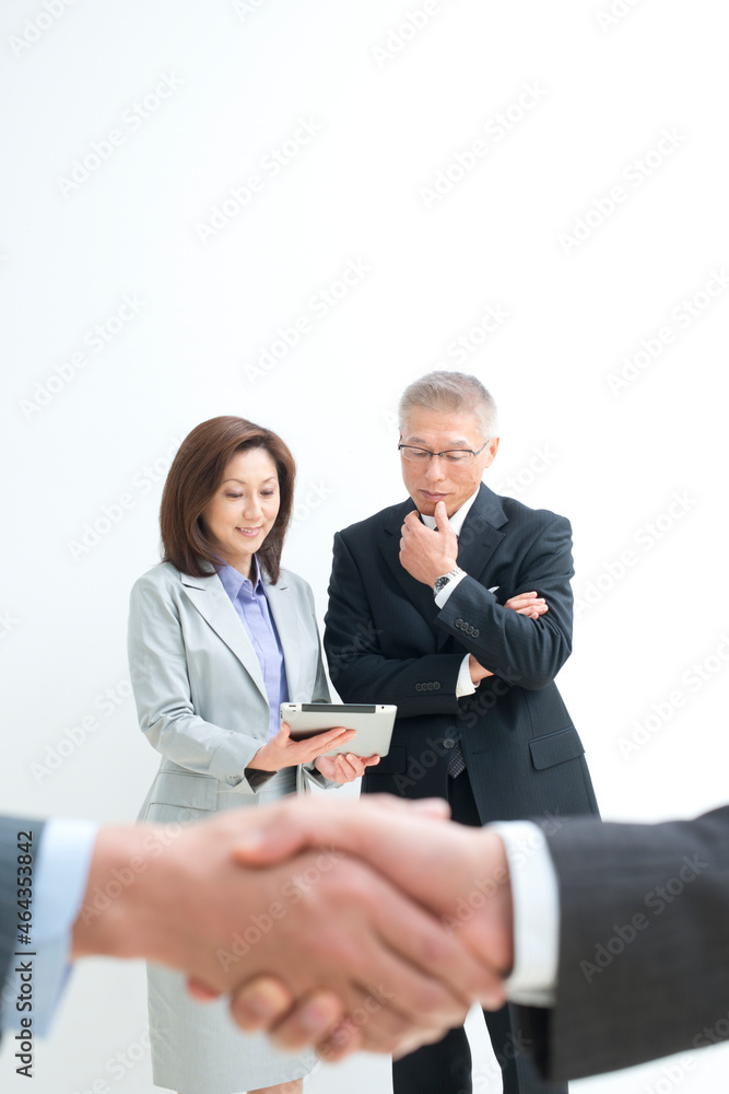 握手する手と中高年ビジネスパーソン 握手する手と中高年ビジネスパーソン
