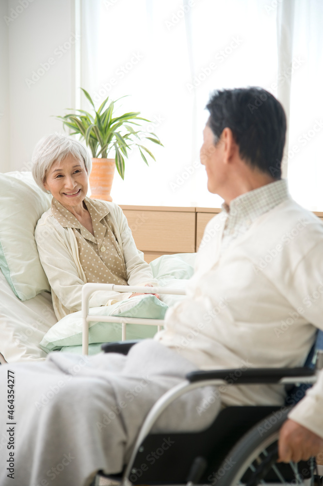介護ベッドと車椅子の老人 介護ベッドと車椅子の老人