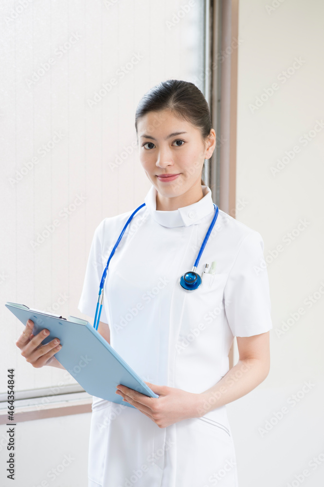 聴診器を首にかけファイルを持つ看護師