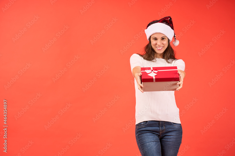 girl in santa claus hat with christmas gift smiling on orange background girl in santa claus hat with christmas gift smiling on orange background