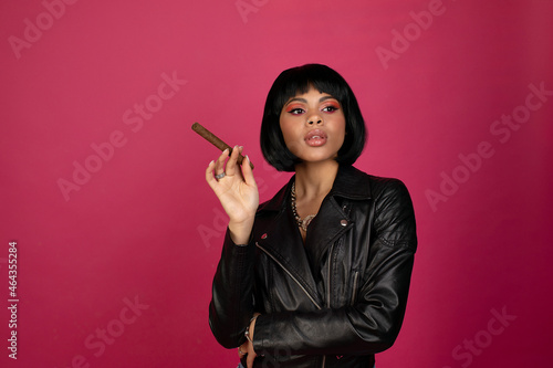 Fotografia Black Woman with cigar on pink background.