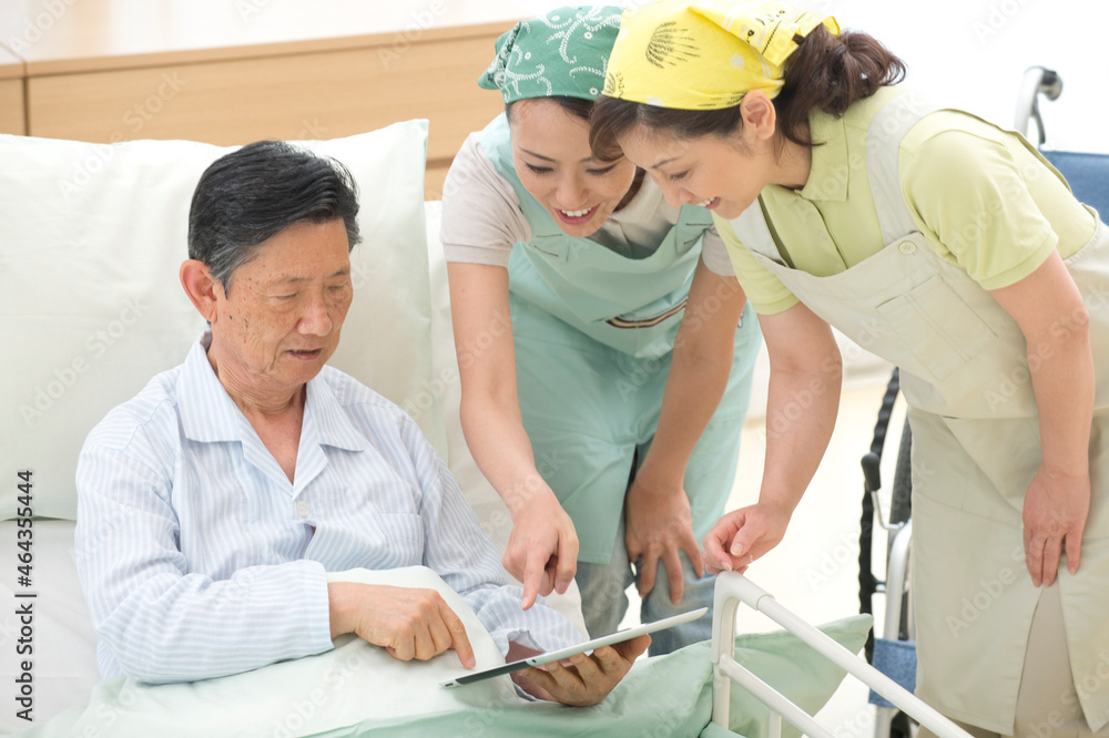 介護ベッドの老人と介護ヘルパー 介護ベッドの老人と介護ヘルパー