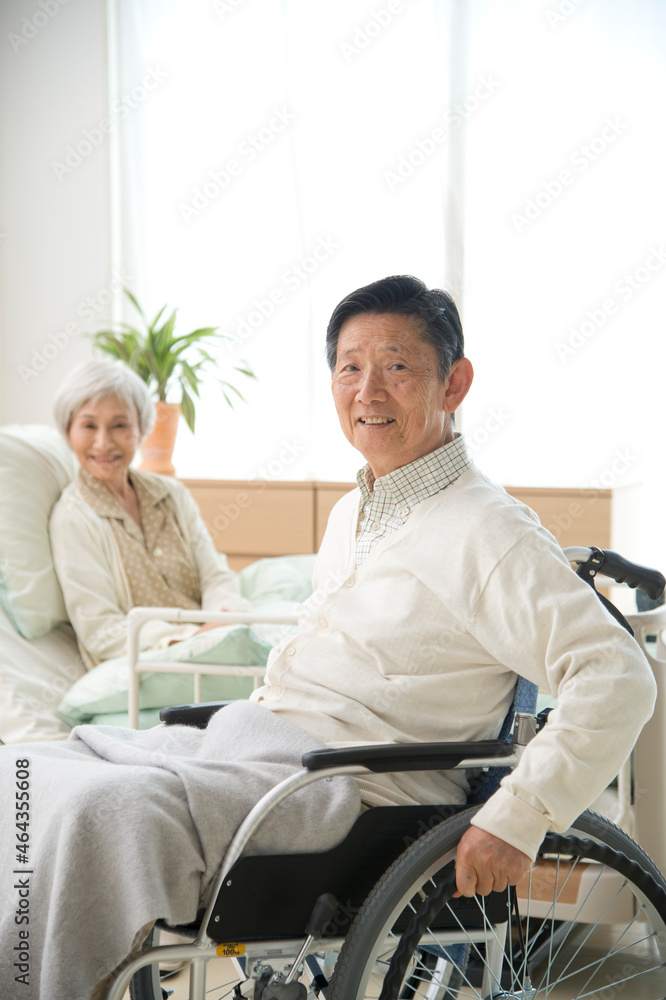 介護ベッドと車椅子の老人 介護ベッドと車椅子の老人
