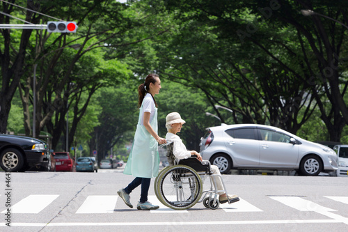 横断歩道を渡る介護士とシニア女性 photo