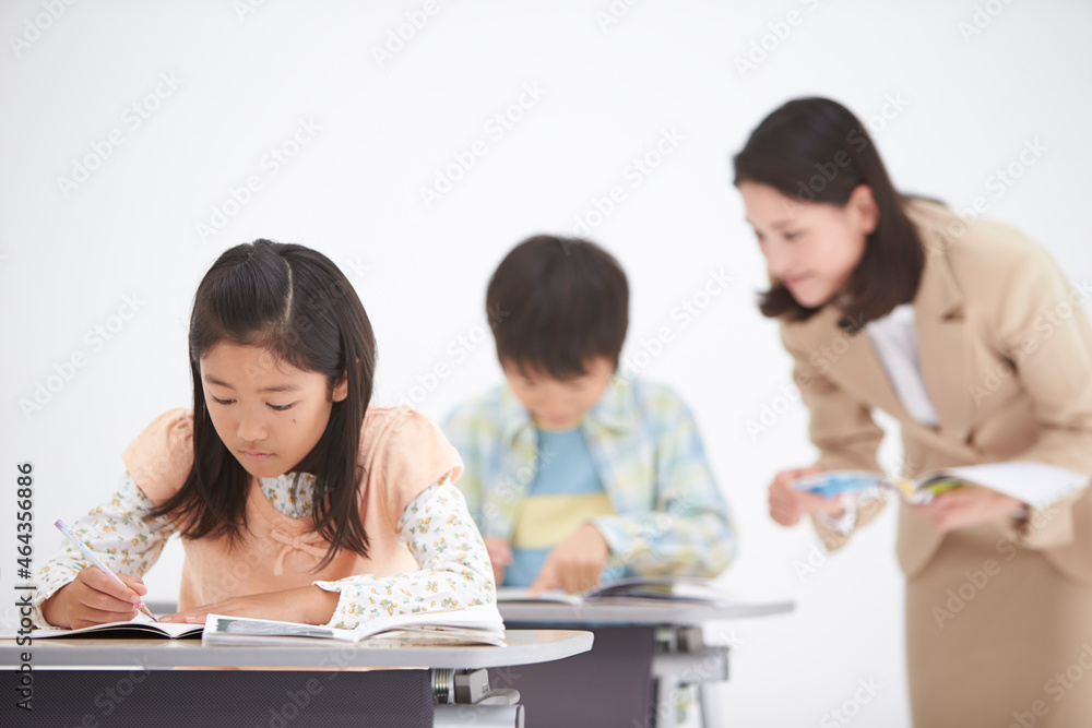 授業中の女性教師と小学生の生徒 授業中の女性教師と小学生の生徒