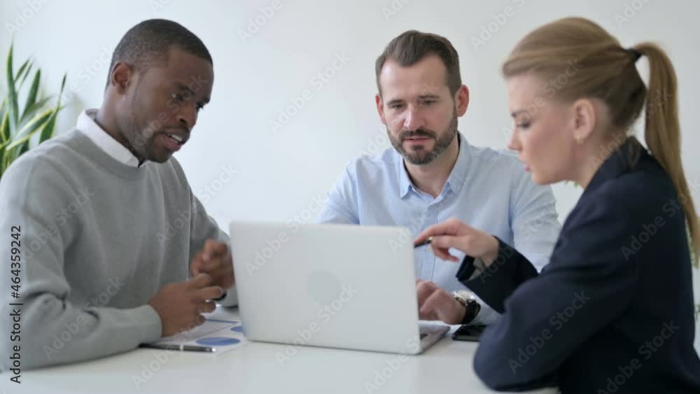 Male and Female Business People having Discussion while using Laptop in Office Male and Female Business People having Discussion while using Laptop in Office