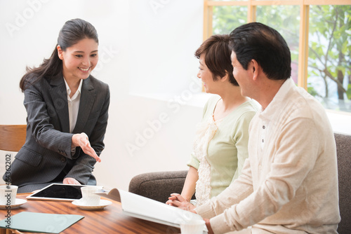 Wallpaper Mural 営業女性スタッフから説明を受ける中高年夫婦 Torontodigital.ca