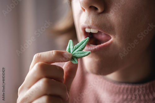 Cbd candy - Woman eating edible cannabis leaf for anxiety treatment - Marijuana alternative medicine photo