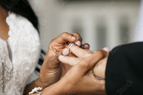 Bride putting on wedding ring on Groom's finger