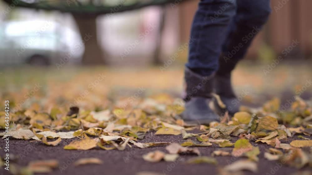 Blurred autumn View of a child kicking autumn yellow leaves into the air. Blurred autumn View of a child kicking autumn yellow leaves into the air.