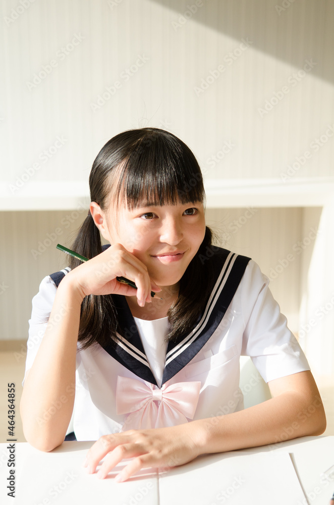 鉛筆を持っている制服姿の女の子