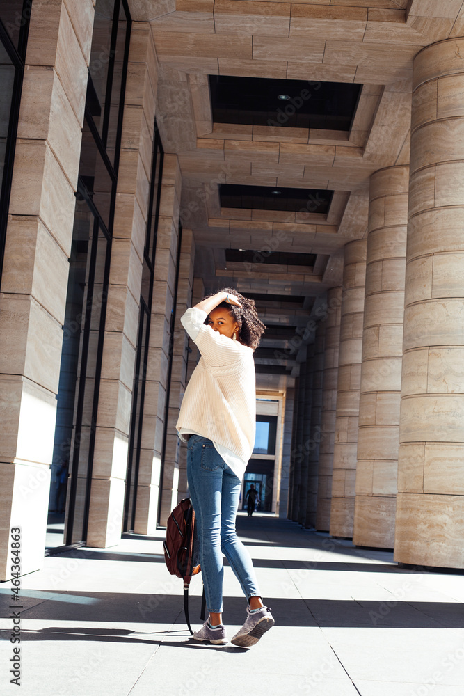 Fototapeta premium young pretty african girl posing cheerful on city background, lifestyle outdoor people concept