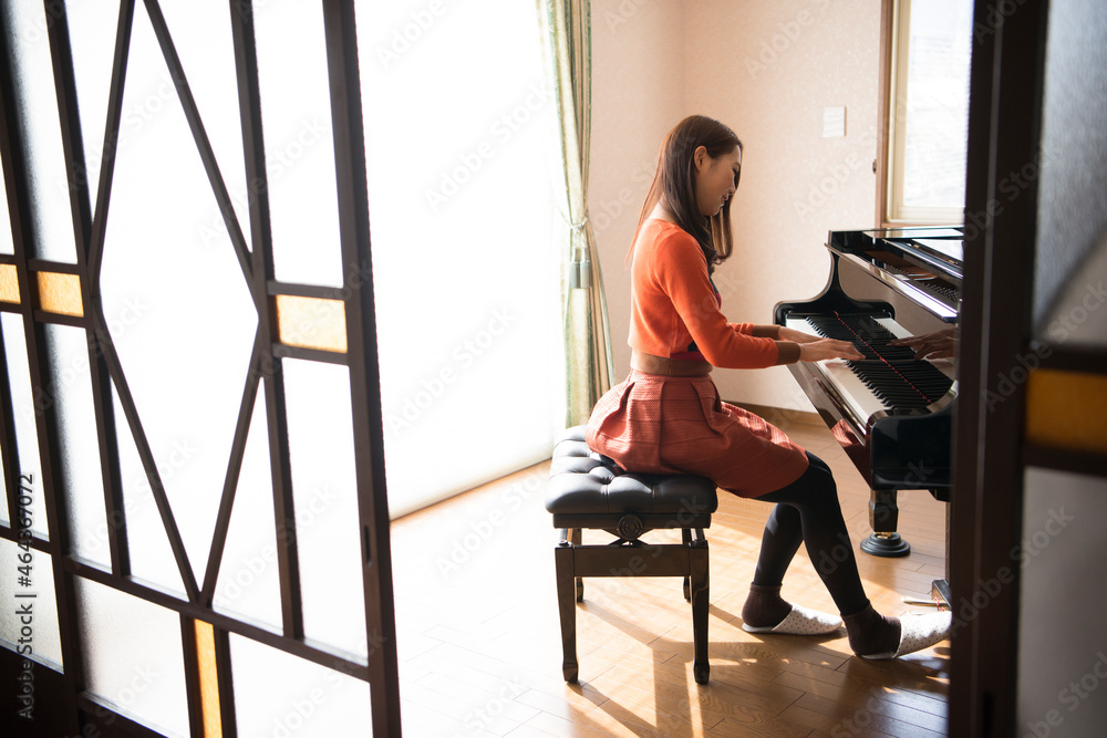 部屋でピアノを弾いている女性 部屋でピアノを弾いている女性