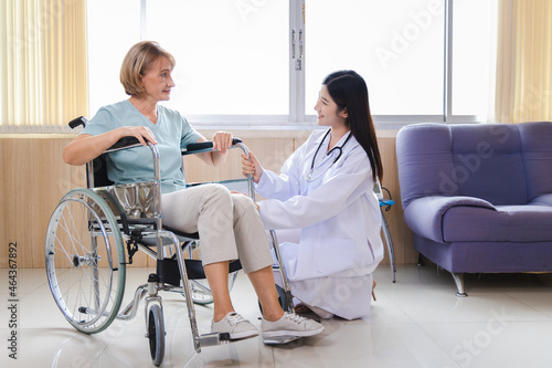 female doctor gives advice and encourages the old woman patient in a wheelchair ​at the hospital.