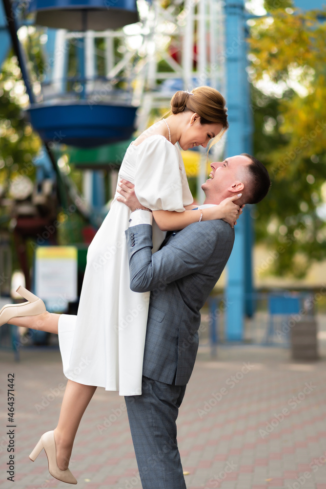 Happy wedding photo of bride and groom with ferris wheel background. Wedding ceremonies and wedding traditions
