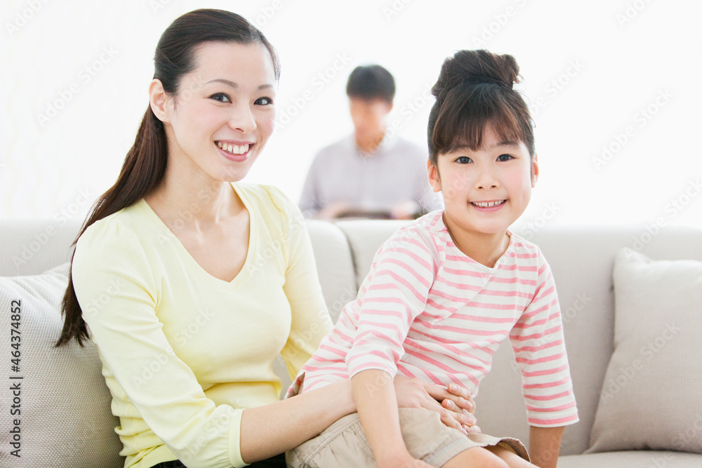 ソファで娘を抱っこする母親 ソファで娘を抱っこする母親