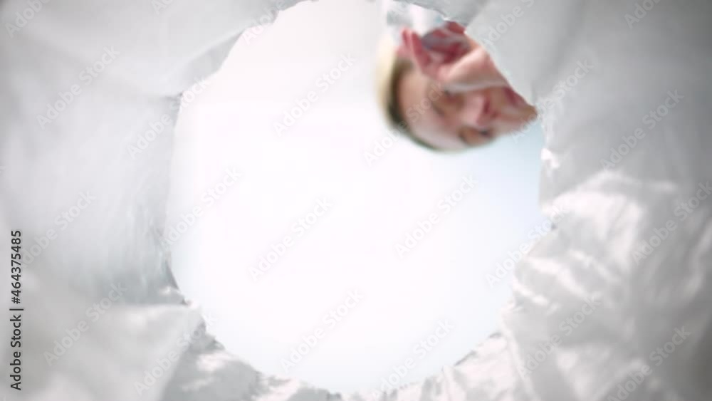 Bottom-up view of a woman throwing face mask into the trash can. Slow motion Bottom-up view of a woman throwing face mask into the trash can. Slow motion
