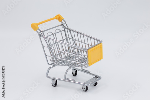 Shopping trolley, on a white background, yellow, empty, with wheels, metal.