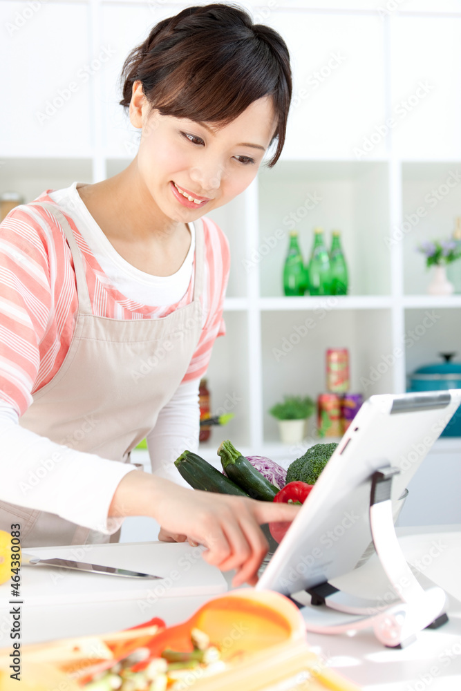 タブレットPCでレシピを見ている女性 タブレットPCでレシピを見ている女性
