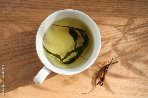 Top view hemp tea in a white cup with cannabis leaf