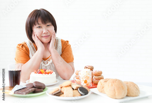 複数の菓子と肥満女性 photo