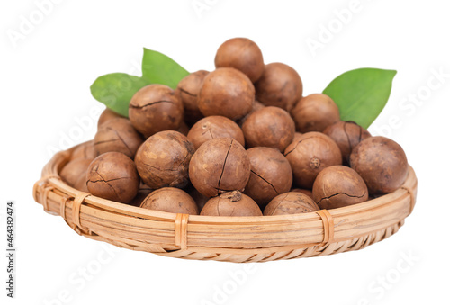 Macadamia nuts with leaves in a straw basket isolated
