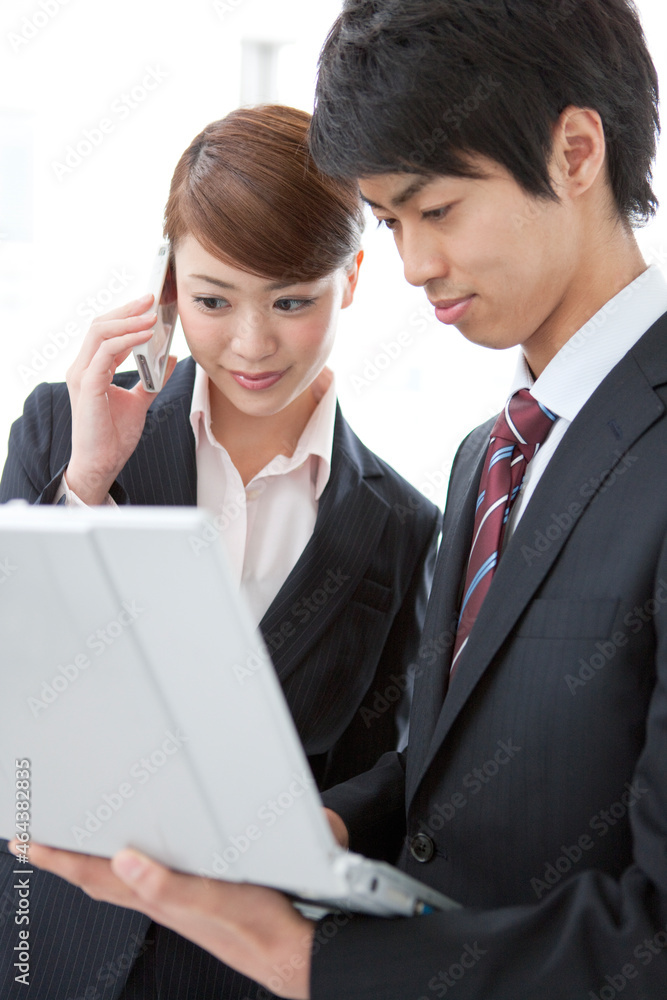 ノートパソコンを見るビジネスマンとビジネスウーマン