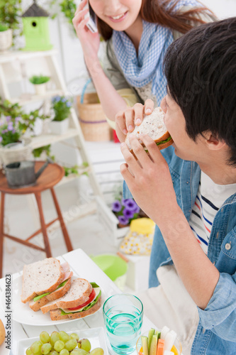 食事する男性と通話している女性