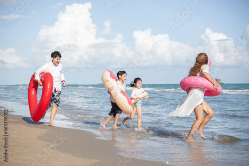 Happy young family Asian running on the beach with copy space. family enjoying