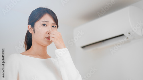 鼻をつまむ女性 エアコンイメージ