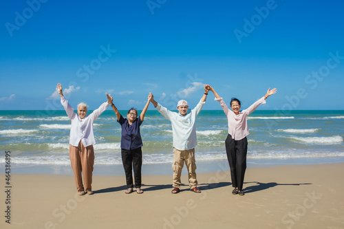 Happy Asian family holding hands and having fun together on tropical beach. Happy family standing on the beach. family travel and vacations concept