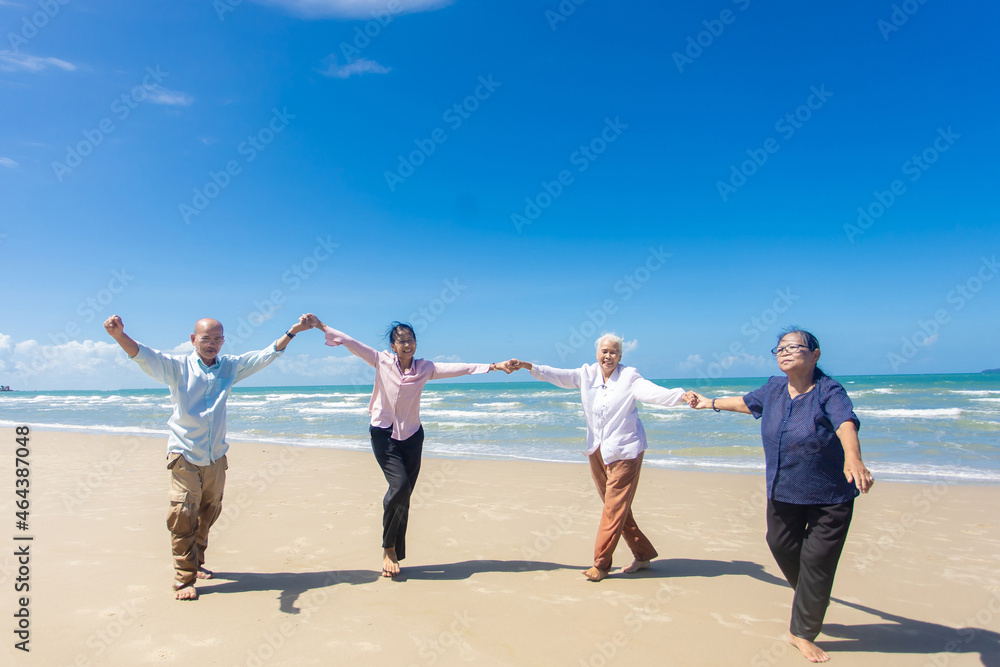 Asian Family Having Fun On Beach. Senior Woman On Holiday On Beach. family holiday and travel summer beach concept Asian Family Having Fun On Beach. Senior Woman On Holiday On Beach. family holiday and travel summer beach concept