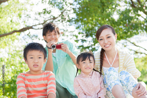 ビデオ撮影する父親と笑顔の家族3人 photo