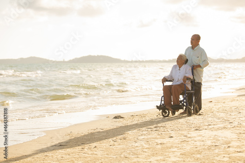 Disabled woman asia in a wheelchair with his family on the beach. Wheelchair woman sitting relax on the beach.  family relax concept