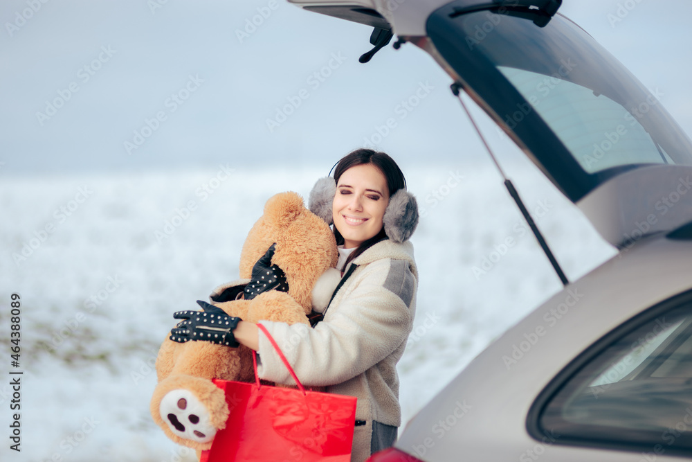 Happy Woman Putting Christmas Gifts in the Car Trunk