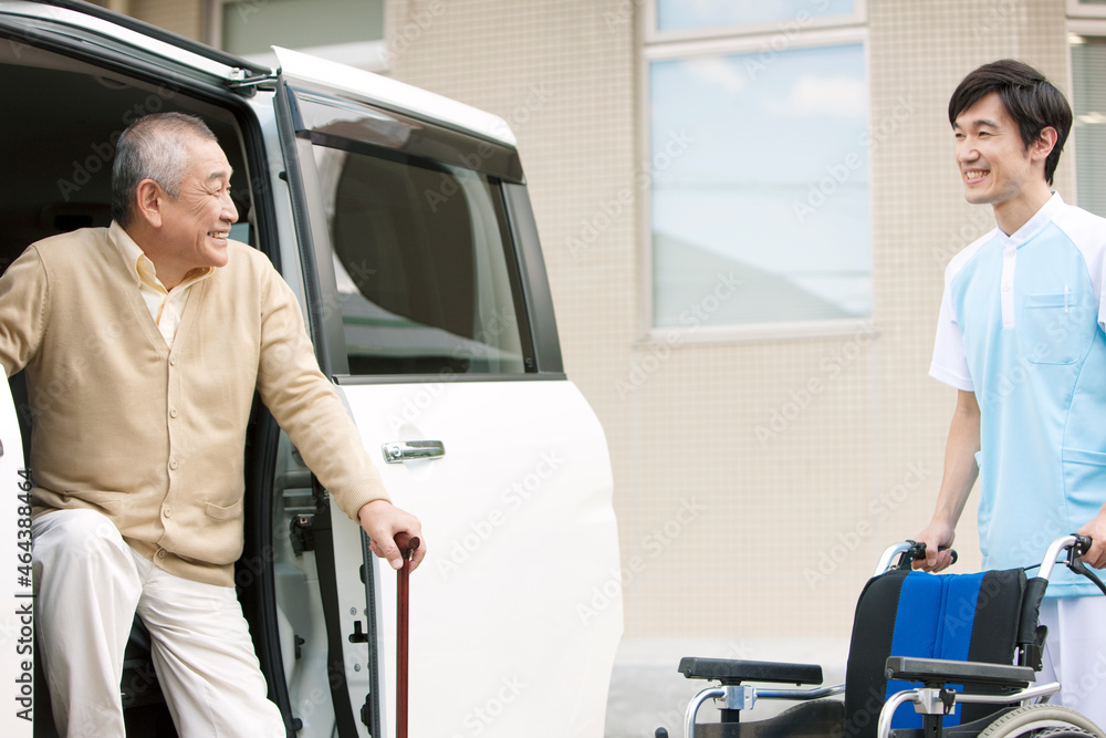 車から降りる杖をつく中高年男性 車から降りる杖をつく中高年男性