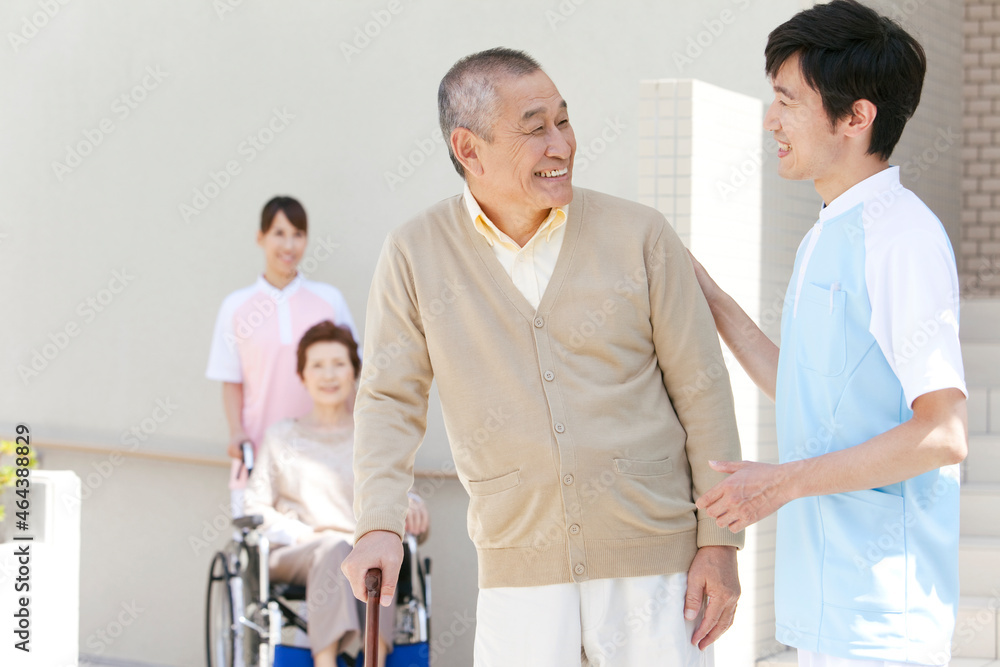介護士と杖をつく中高年男性 介護士と杖をつく中高年男性